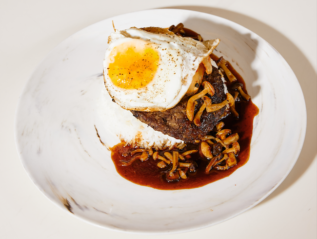 Loco moco Hawaiian dish with rice, mushrooms, patty, and egg on white plate